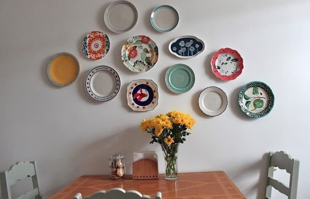 ایده خلاقانه برای چیدمان بشقاب دکوراتیو در دیوار نشیمن چیدمان بشقاب دیوارکوب دکوراتیو روی دیوار پذیرایی با سبک هنری
