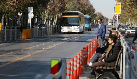مسافران در ایستگاه بی‌آرتی در حال انتظار برای اتوبوس.
